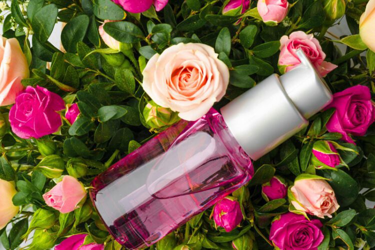 Bottle of fragrance or aromatic oil in a bunch of fresh flowers